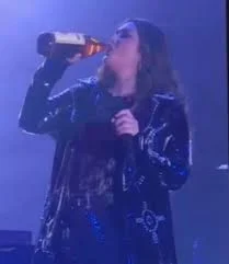 Yuridia bromea con el publico y le dan una bebida