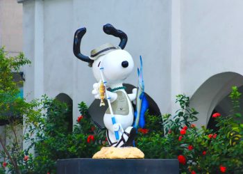 Turistas reciben a la emblemática estatua de Snoopy, completamente rehabilitada.